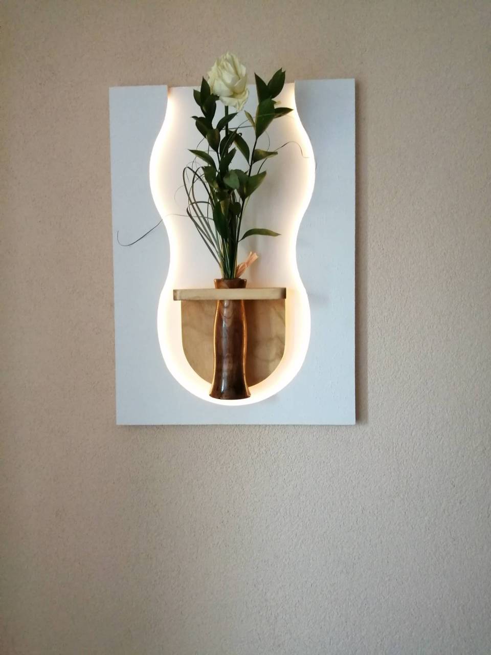 Drevená dekorácia na stenu s LED osvetlením a drevenou vázičkou.
